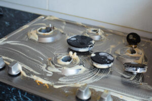 Gas range stove repair in progress by a technician.